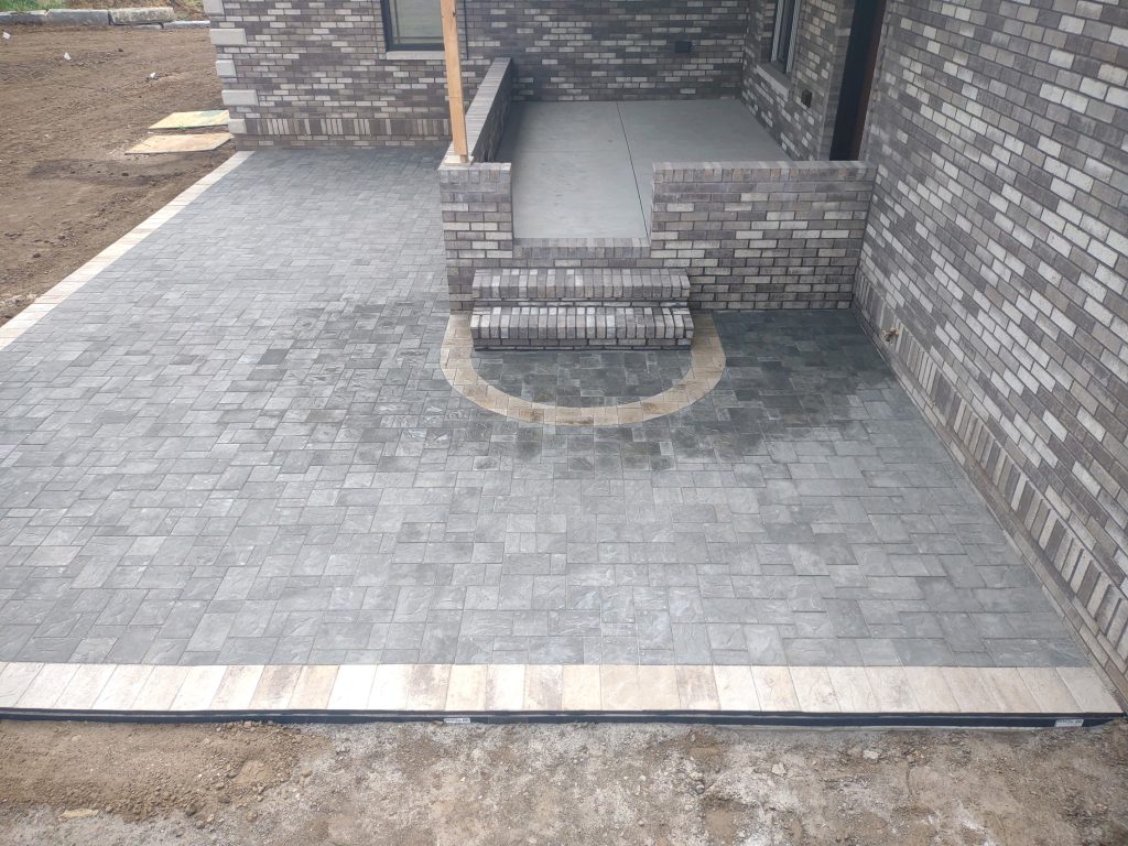 A new home build is finished with a detailed, grey stone patio.