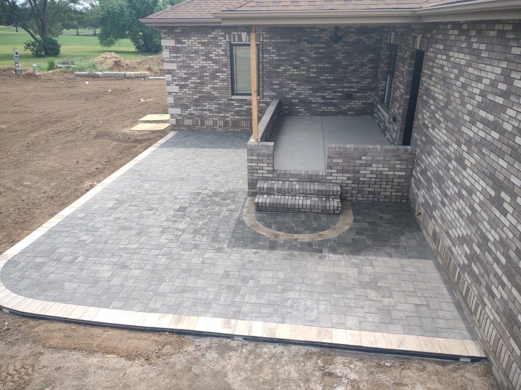 A new home build is finished with a detailed, grey stone patio.